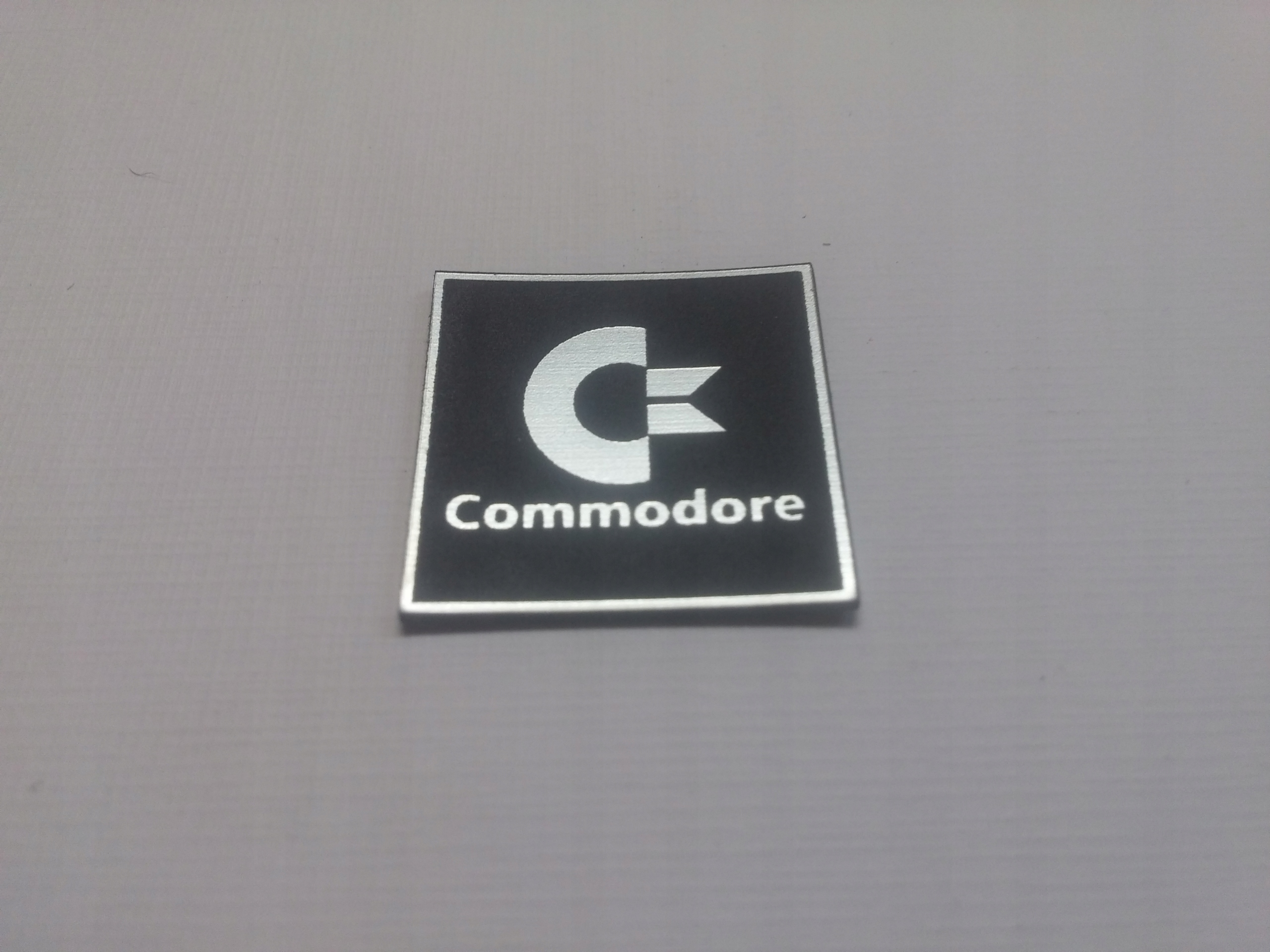 

Commodore naklejka emblemat 24 x 24 mm *srebrna