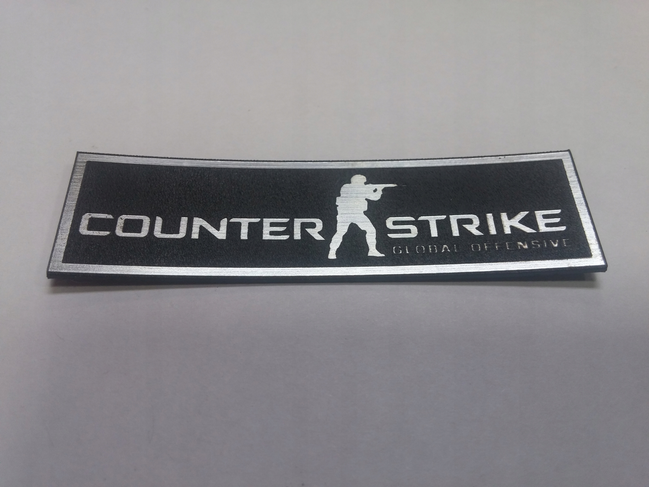 

Counter Strike naklejka emblemat 64 x 18mm*SREBRNA