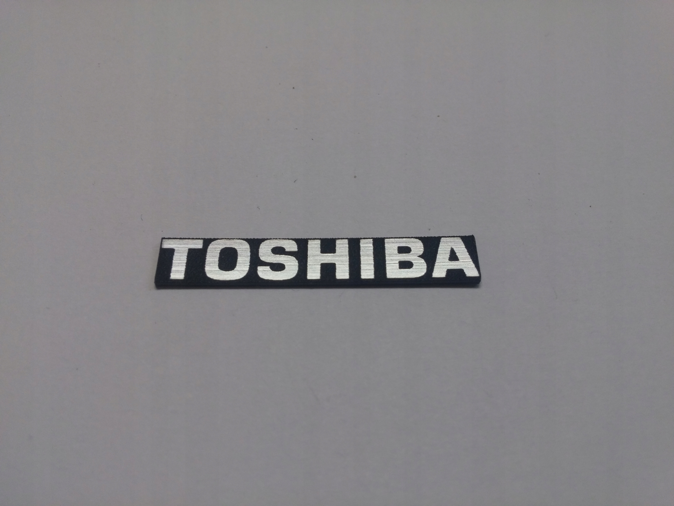 

Toshiba naklejka emblemat 40 x 6 mm * Srebrna