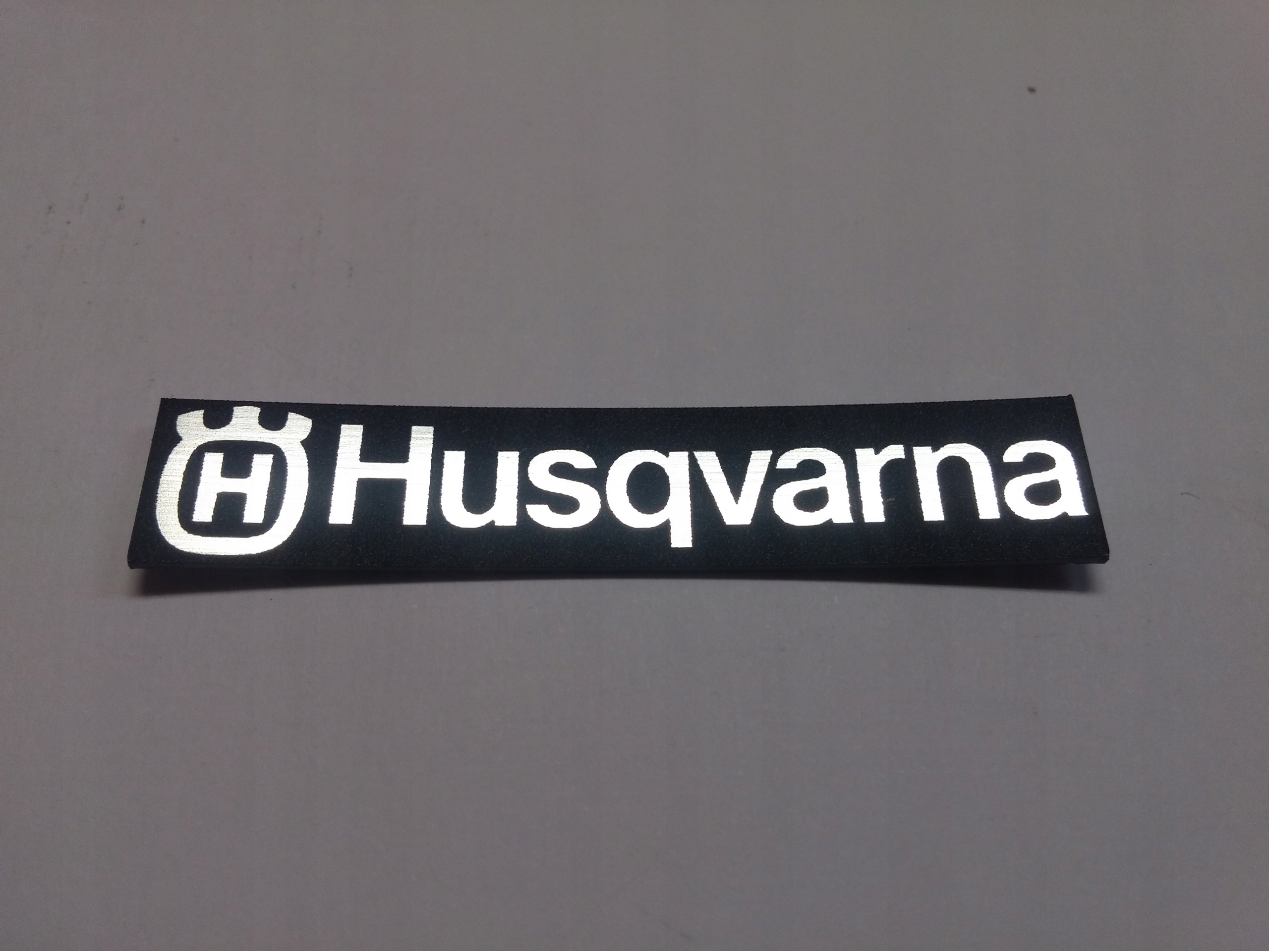 

Husqvarna naklejka emblemat 58 x 11 mm*SREBRNA