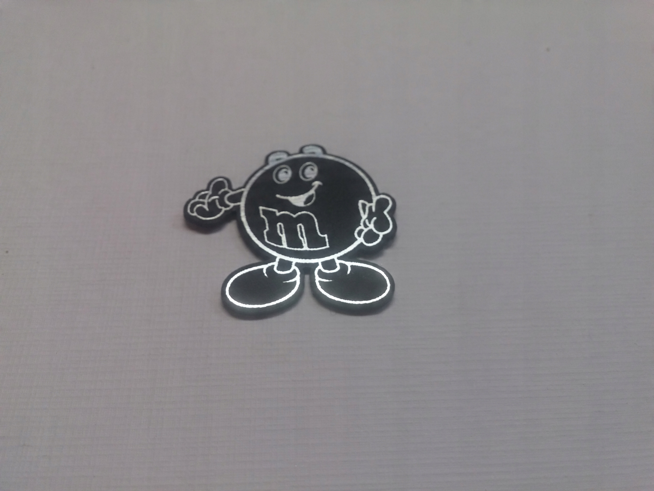 

M&M naklejka emblemat 26 x 26 mm *srebrna
