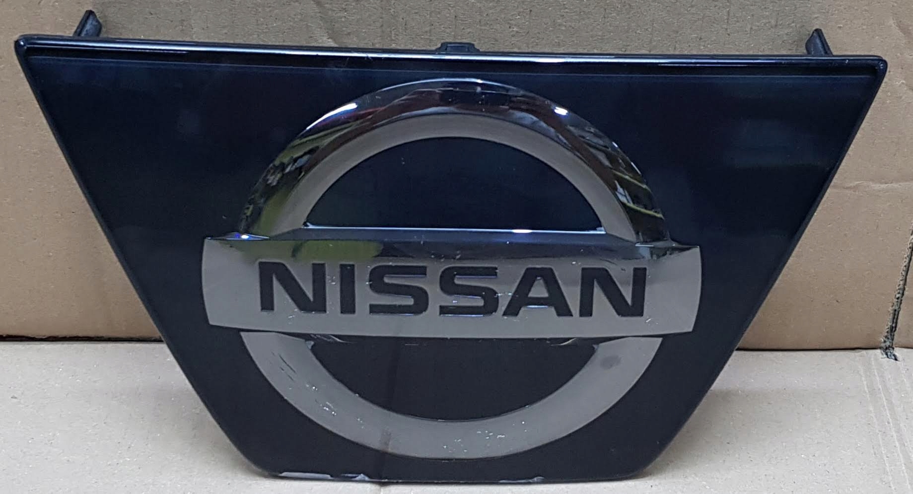 NISSAN QASHQAI II LIFT EMBLEMAT ZNACZEK GRILLA ZDERZAKA PRZÓD 62890-HV01A