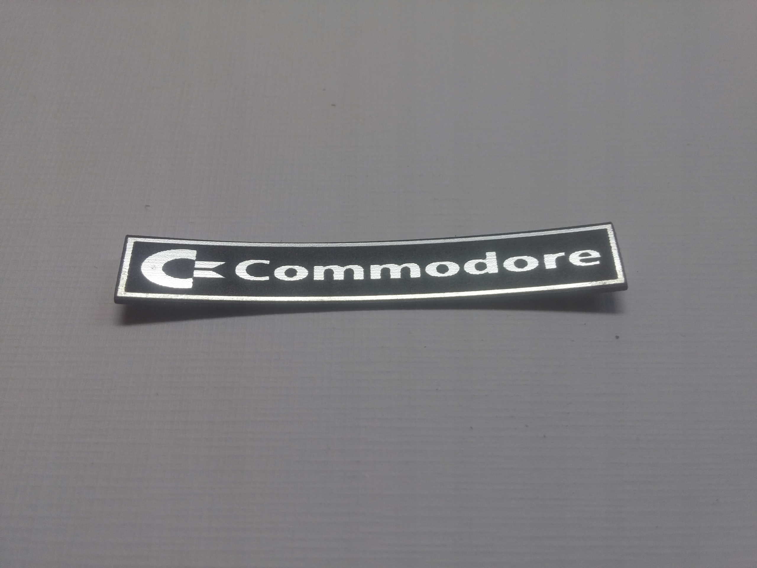

Commodore naklejka emblemat 48 x 7 mm *srebrna