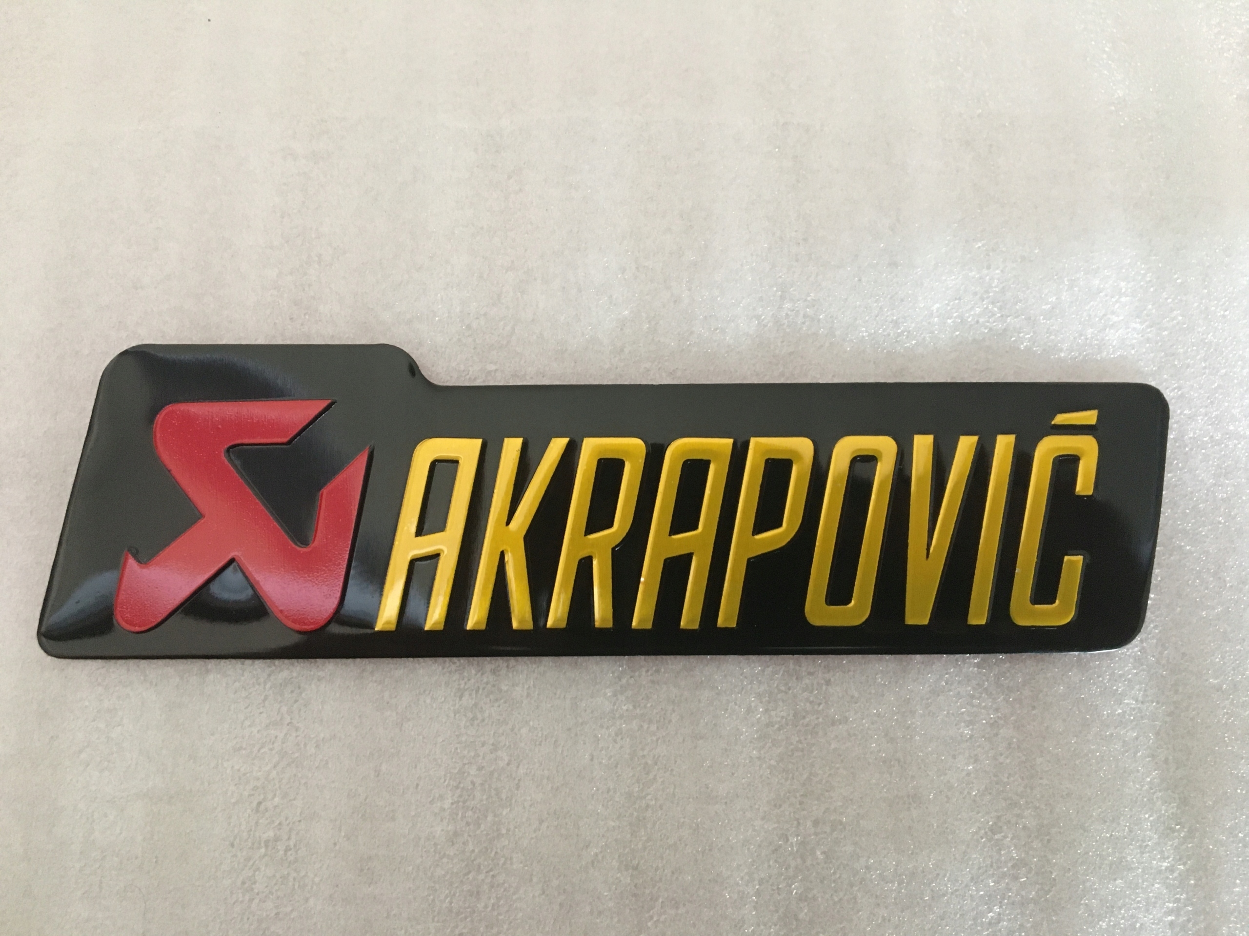 EMBLEMAT NAPIS ALU NAKLEJKA WYDECHU MOTOCYKLA MOTORU 10x2,6 CM Numer katalogowy części AKRAPOVIC