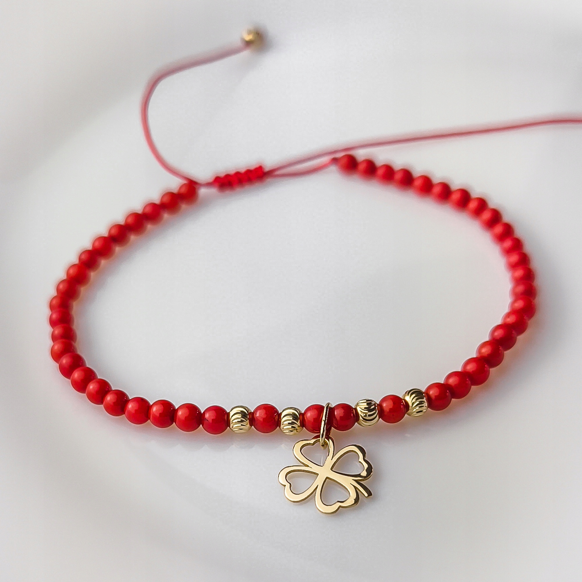 Zlatý náramek na provázku z červených korálků s koničinkou ryzosti 585