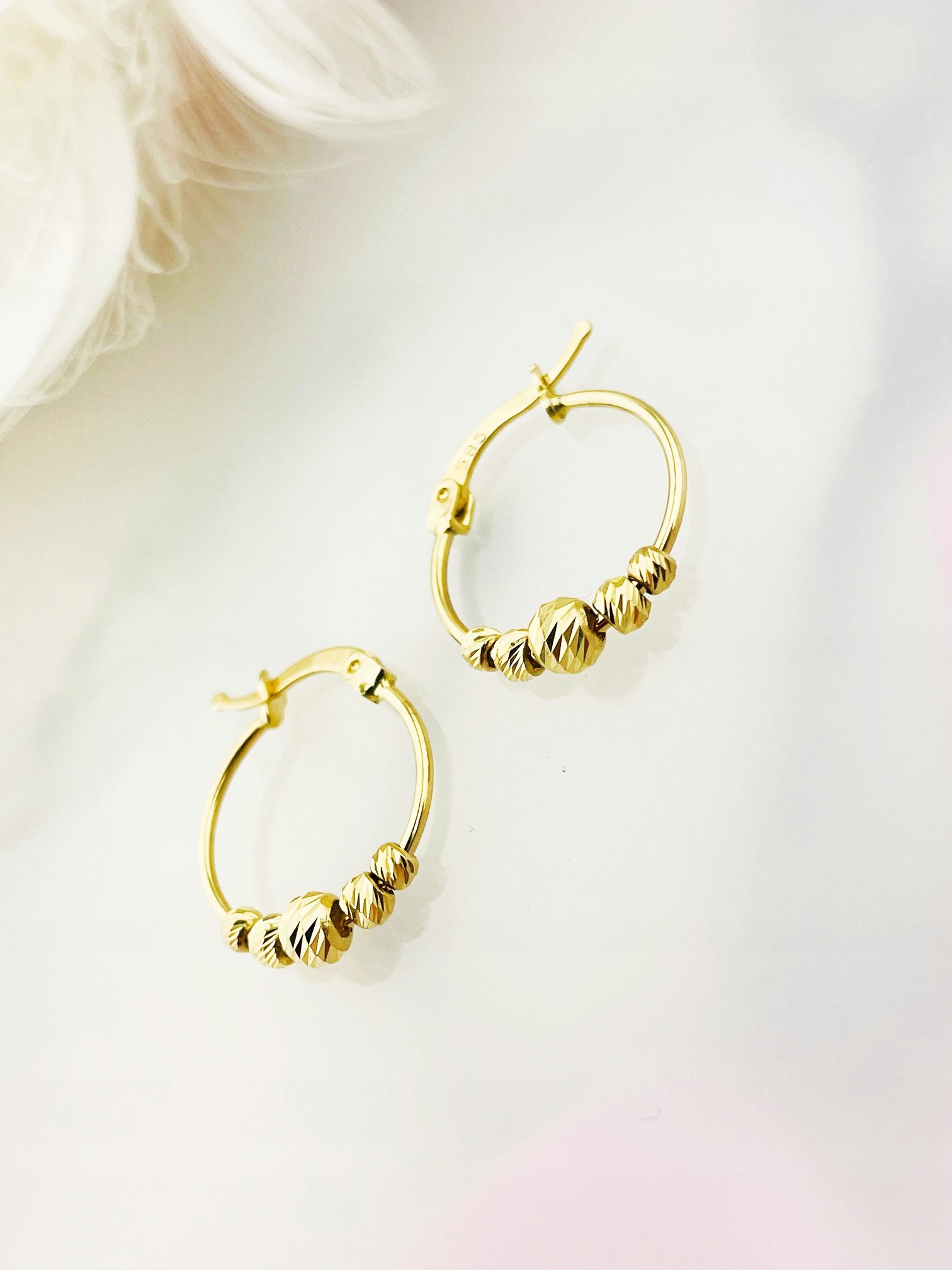 Zlaté kruhové náušnice s leštěnými kroužky a korálky