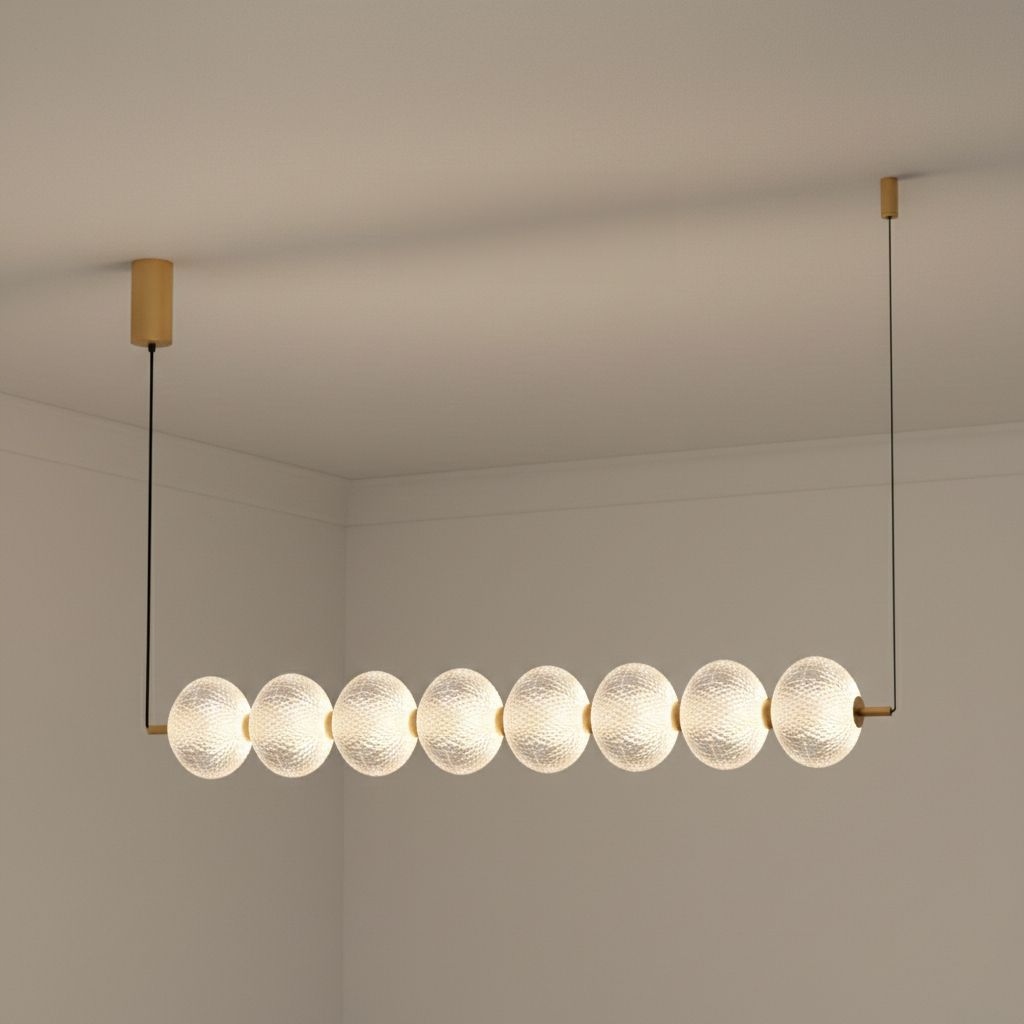 Exkluzívna lampa s zavesenými guľami na zlatom nosníku nad ostrovom Galatea