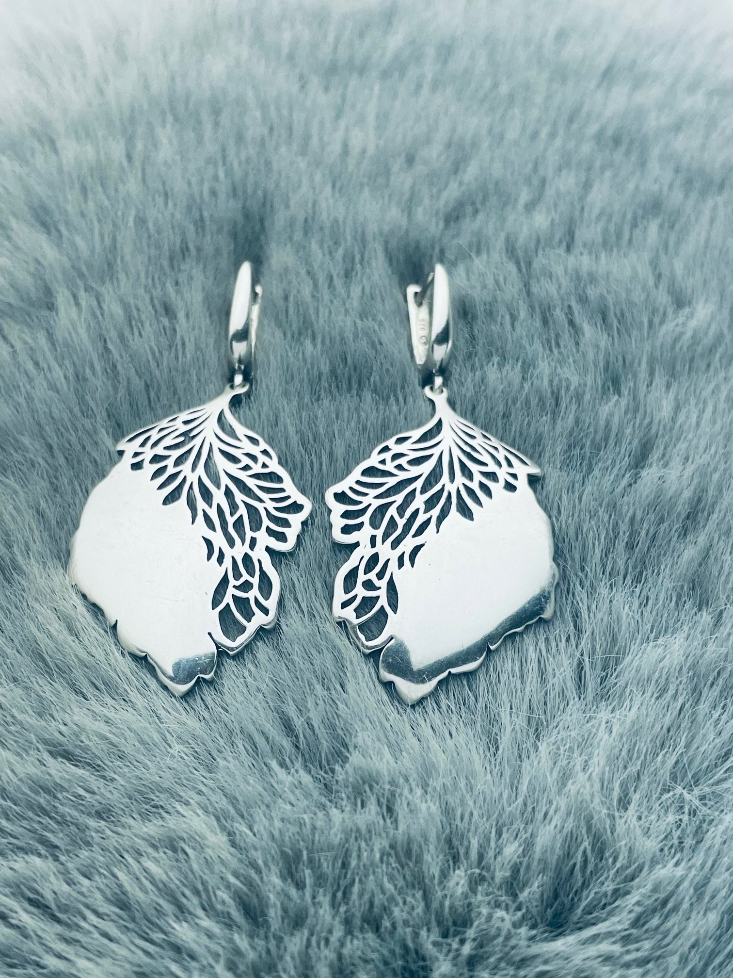 Stříbrné náušnice zavěšené na leštěném, ažurovém listí
