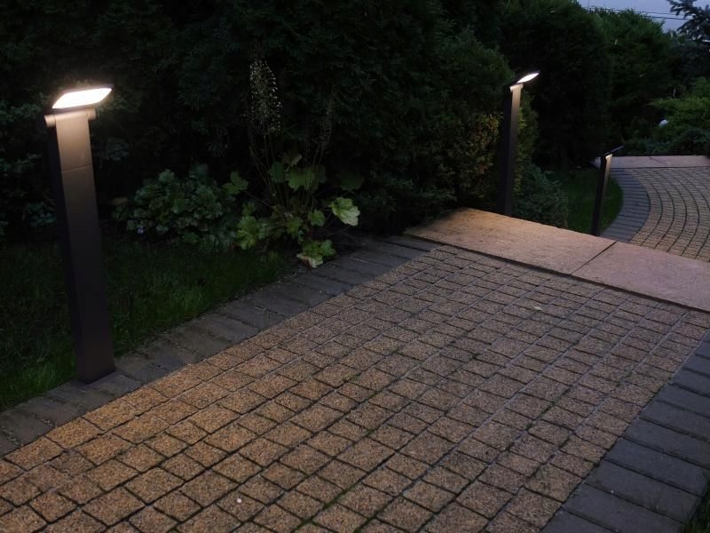 Záhradný stĺpik s úzkou násadou 60 cm pred vstupom do garáže Neo, sivý