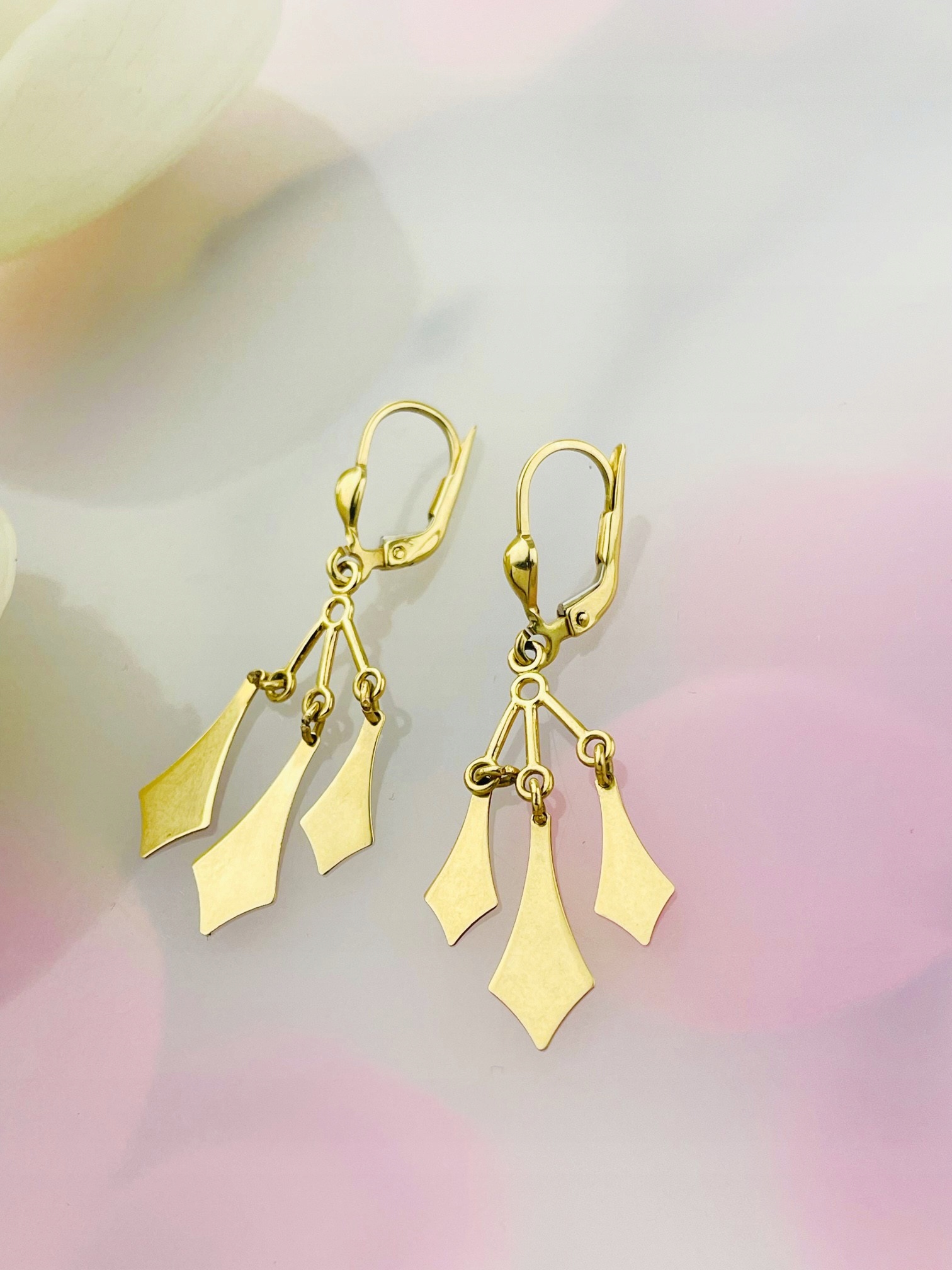 Zlaté náušnice visící na káro