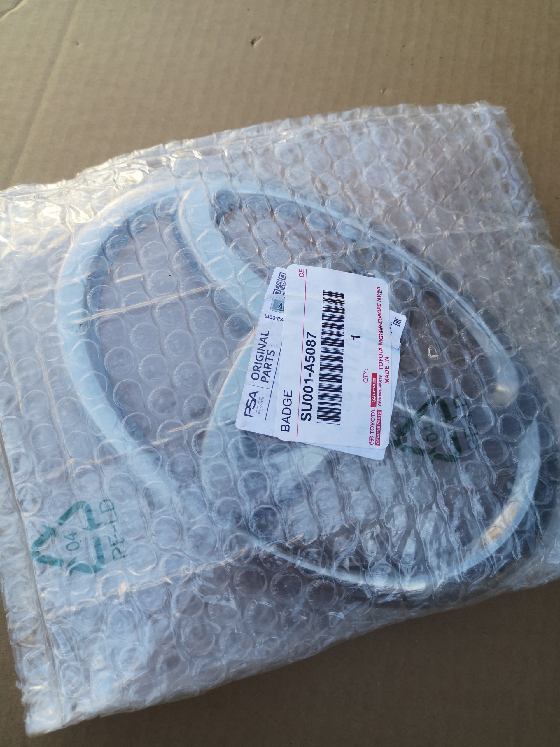 EMBLEMAT LOGO TOYOTA PROACE SU001-A5087 NOWY ORYGINAŁ Numer katalogowy części 9811709777
