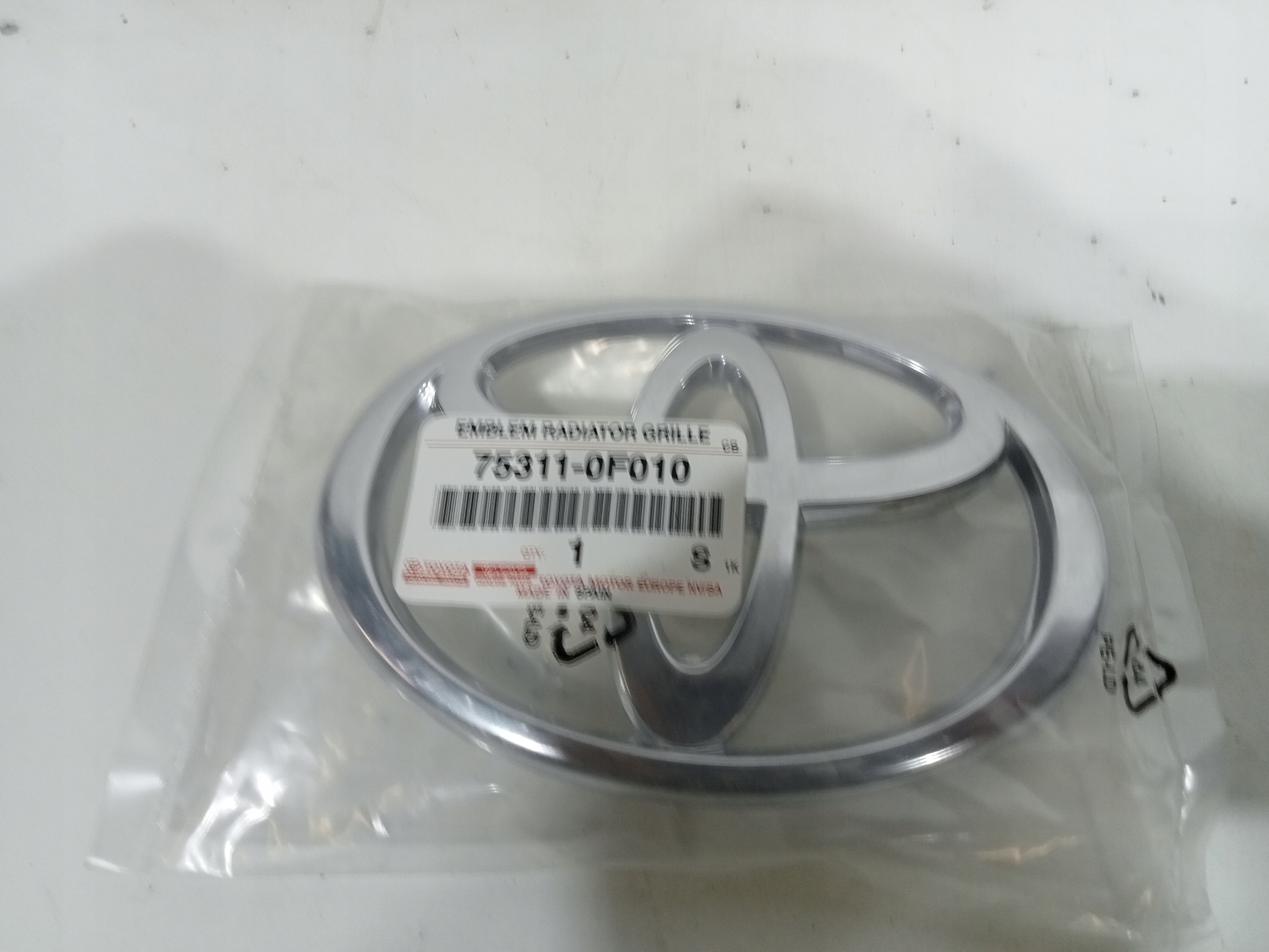 TQ-026 ZNACZEK EMBLEMAT ATRAPY PRZÓD COROLLA VERSO 04-07 75311-0F010