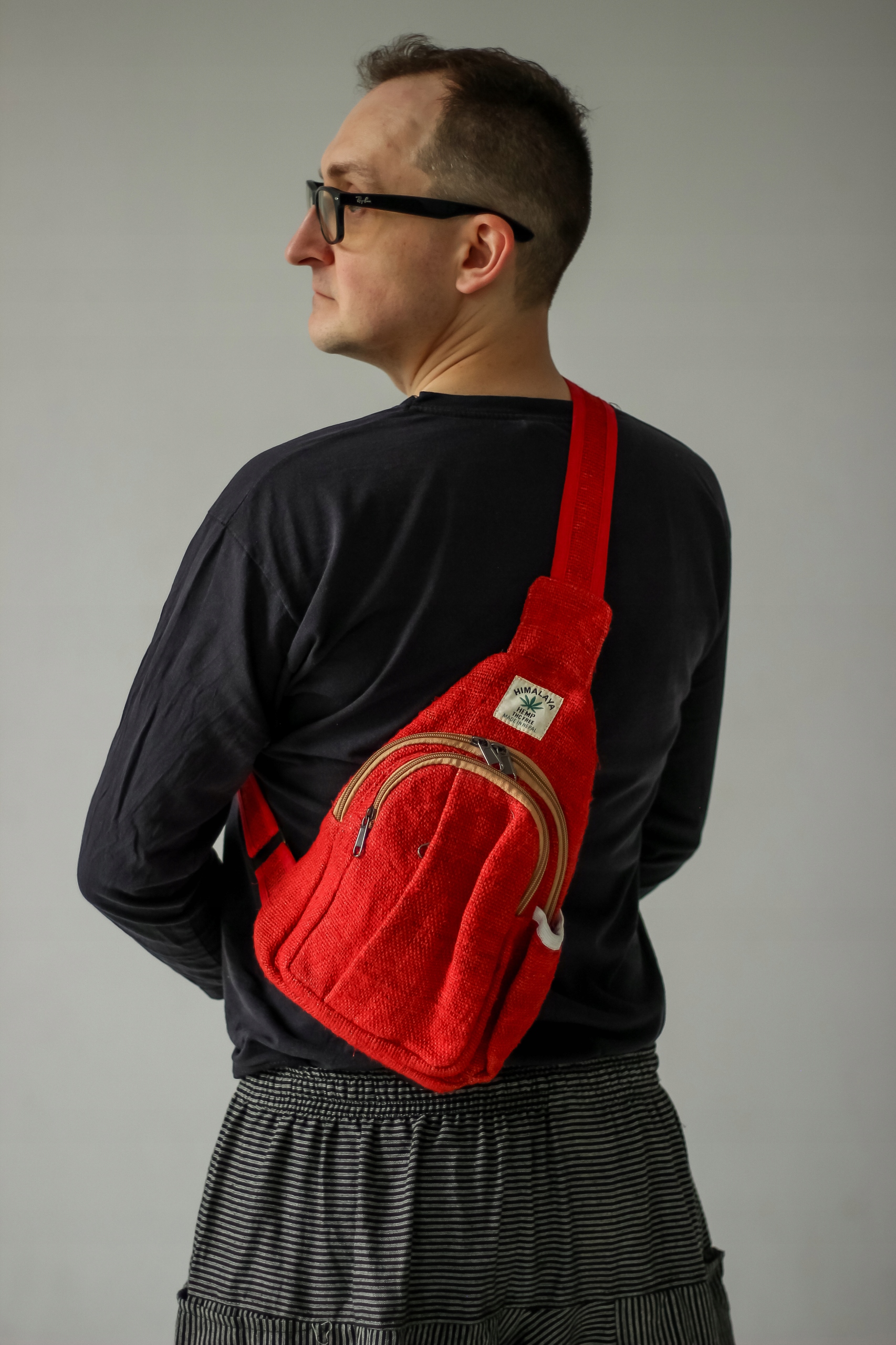 Červený trojúhelníkový batoh z konopí Himalayan Hemp mini přes rameno