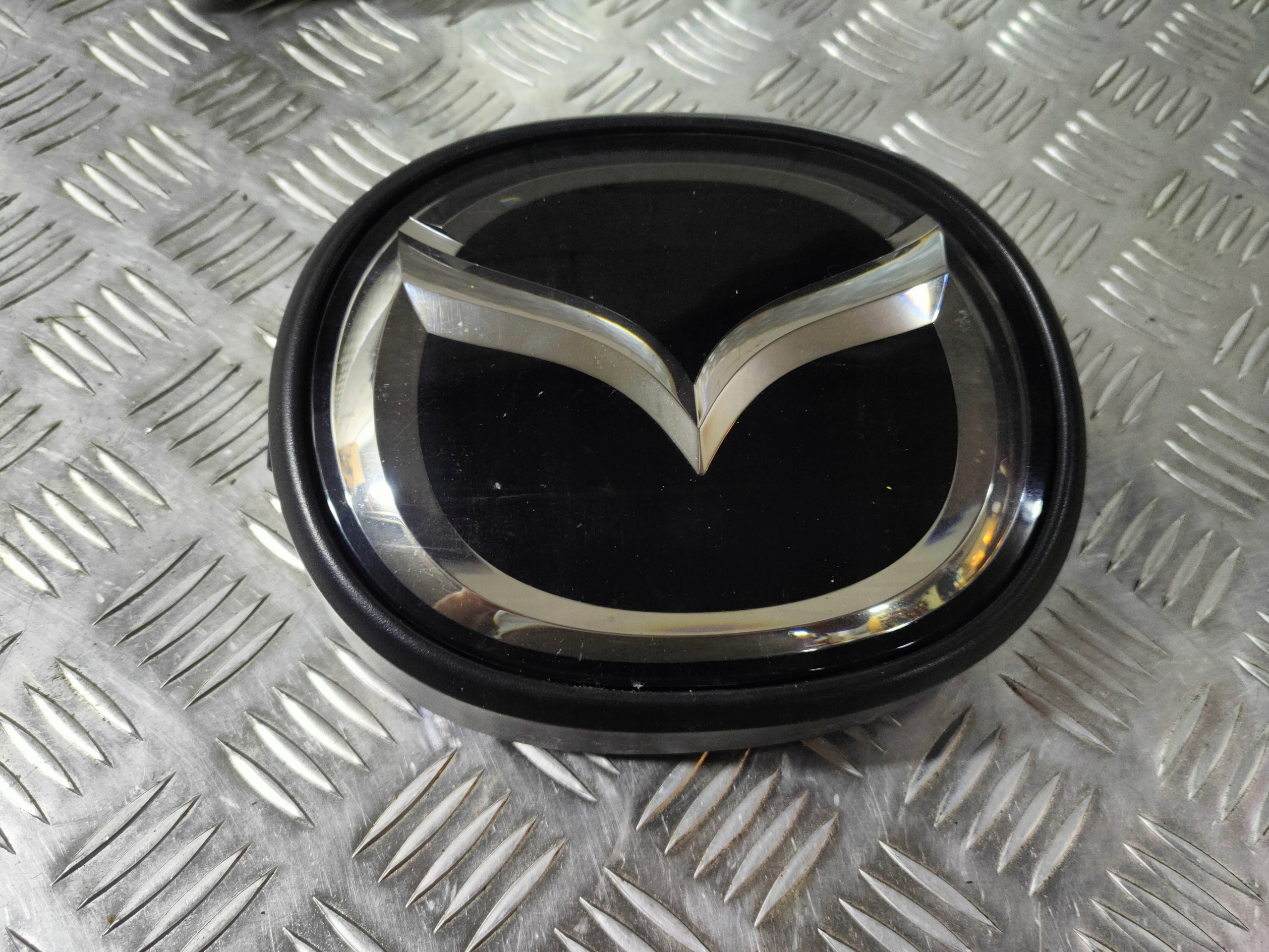 Mazda CX5 CX-5 GHR6-51730 LOGO EMBLEMAT ZNACZEK ZDERZAKA PODSTAWA LIFT 2016