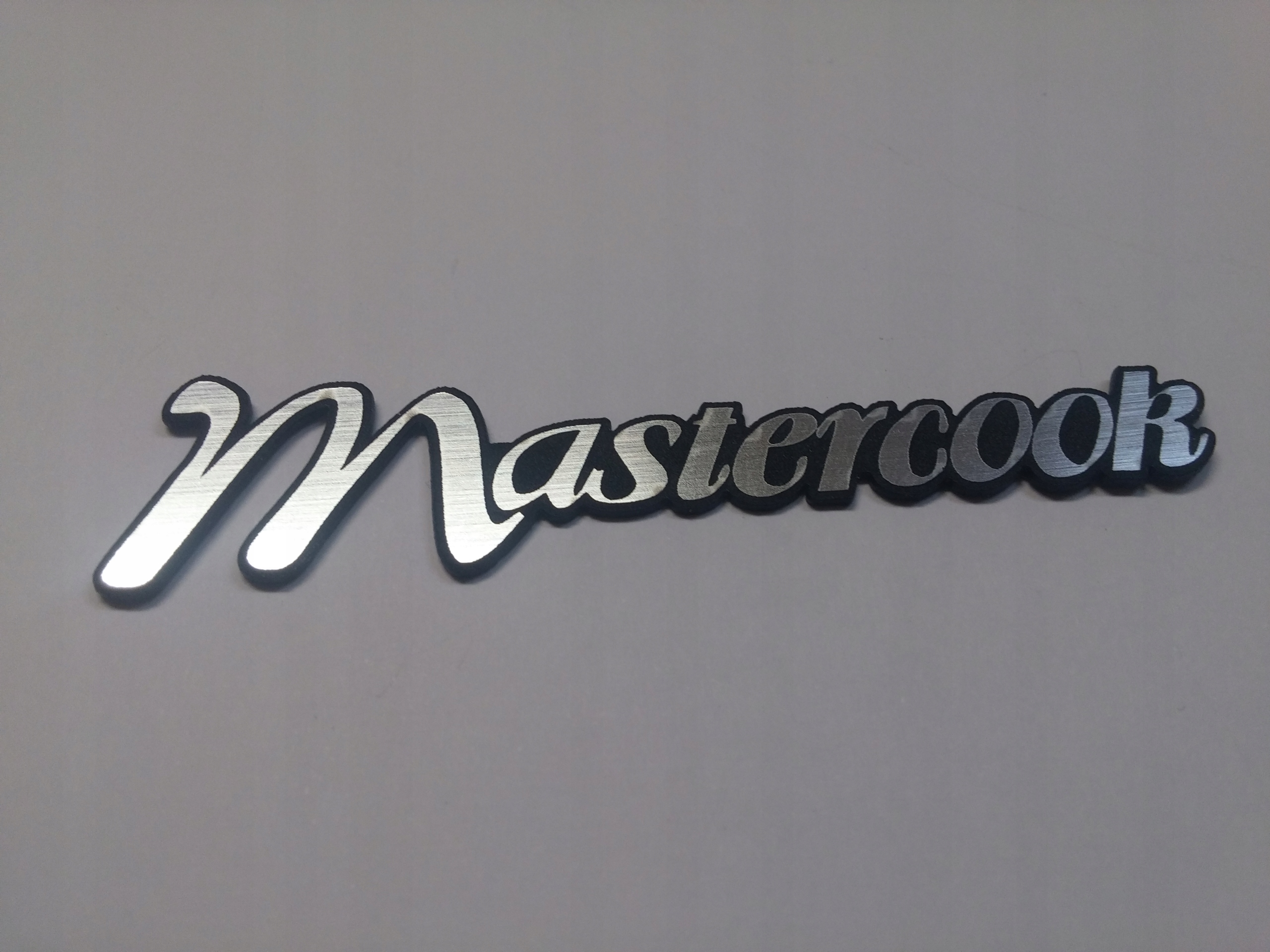 

Mastercook naklejka emblemat 82 x 20 mm *srebrna