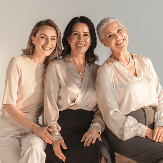 Silk Blouses: Three women wearing beige satin tops, pearl necklaces.