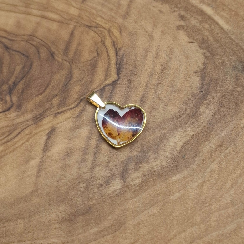 Wisiorek z żywicy serce z jesiennymi listkami na białym tle WOŚP