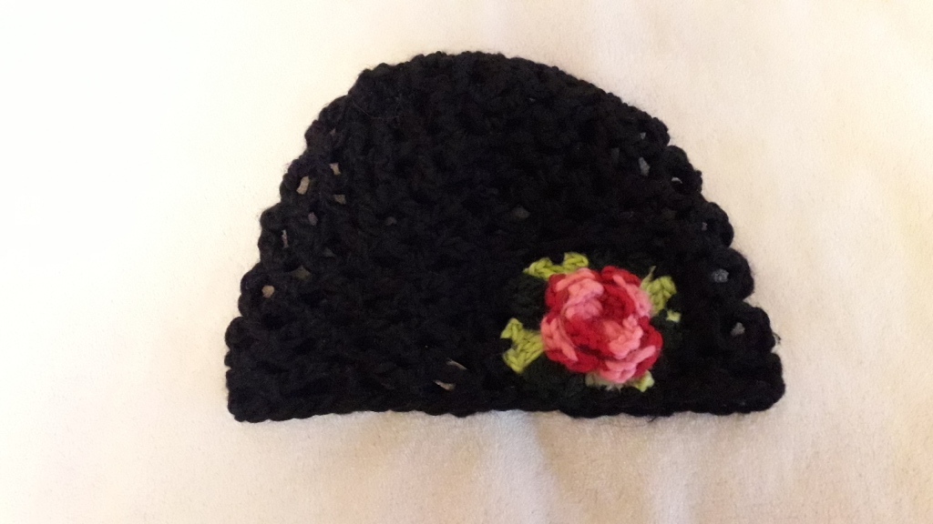 Czarna czapka z różą, na drutach