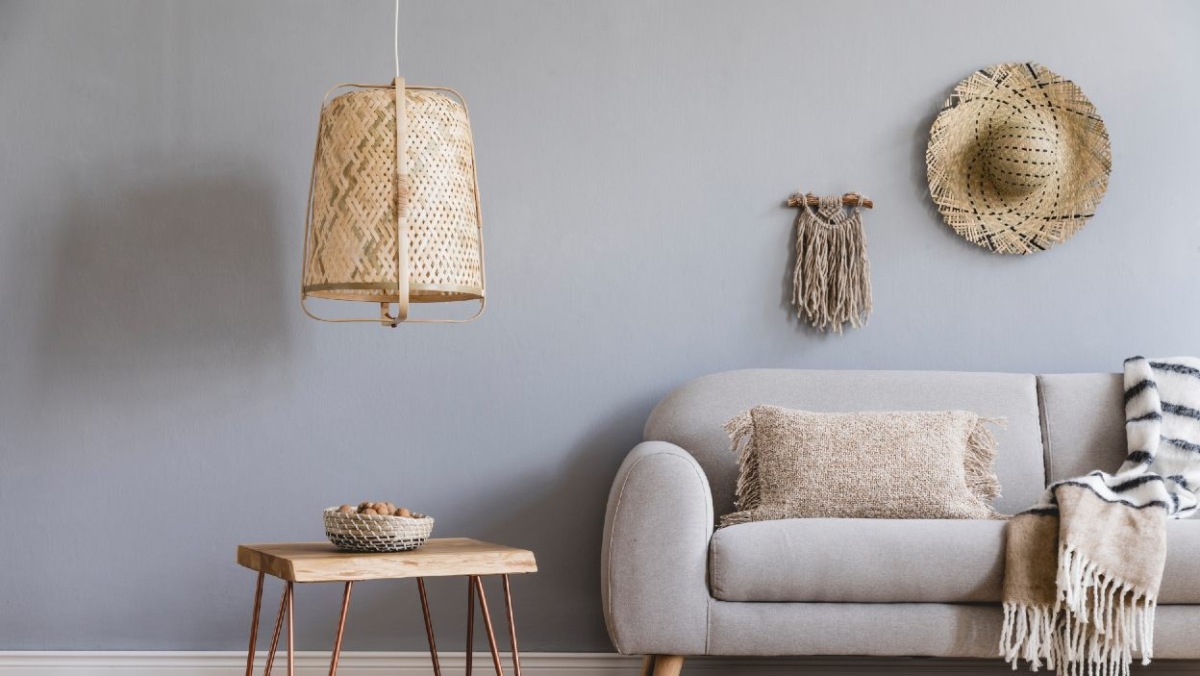 Pohovka do obývačky v štýle boho s vankúšmi a malým konferenčným stolíkom a závesnou lampou boho