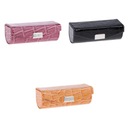 Футляр для губной помады темно-коричневого, черного и оранжевого цвета.