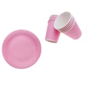 Набор розовых бумажных тарелок и чашек.