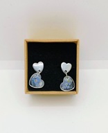 Srebrne kolczyki serduszka wiszące z niezapominajkami na srebrnym tle.