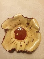 Brązowo-beżowa misa ceramiczna o falowanych brzegach.