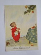 Dziecko z lalką stoi przed choinką - stara pocztówka