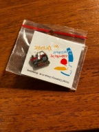 Znaczek 2018 URSUS rekonstrukcja neonu, trzy ruchome ciągniki na budynku.