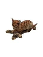 Figurka kot rudy pręgowany leżący na gałęzi