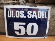 Stara emaliowana tablica z numerem domu i ulicą