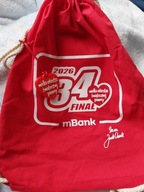 Plecak worek wolontariusza 34 Finału WOŚP i serce świecące w ciemności.