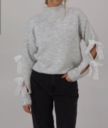 Sweter z  koronkowymi kokardkami na rękawach 