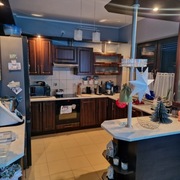 Meble kuchenne z półwyspem i  ciemnymi frontami.