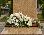 Piękna kompozycja na cmentarz ze storczyków i białych róż na brązowej desce