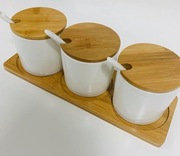 Zestaw 3 ceramicznych pojemników z łyżeczkami na bambusowej podstawce.