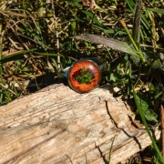 Pierścionek z żywicy z zielonymi listkami na miedzianym tle