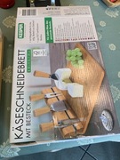 Deska do serwowania serów, ze sztućcami.