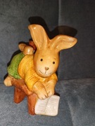 Figurka ceramiczna królik na krześle z książką 