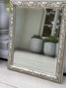 Lustro prostokątne w srebrnej ramie.