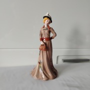Figurka porcelanowa „Dama z torebką”; figurka damy w brązowej sukni