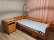Łóżko rehabilitacyjne z uchwytem, szafką i materacem przeciwodleżynowym