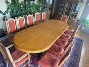 Owalny stół z 12 krzesłami dębowymi.