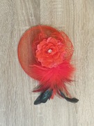 Czerwony fascynatr z kwiatem i piórami 
