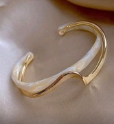 Elegancka bransoletka bangle w kolorze złotym z jasnym wykończeniem