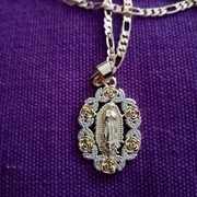 Łańcuszek z medalikiem z wizerunkiem MB z Gwadelupe w kolorze złotym. 