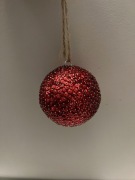 Czerwona bombka cekinowa o średnicy 8 cm.
