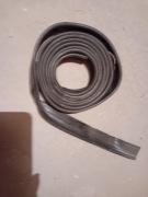 Syrena taśma plastikowa pomiędzy tylnym błotnikiem, a nadwoziem.