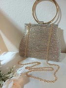 Piękna złota torebka wizytow na okrągłych kołach.