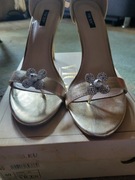 Czółenka koloru tęczowego i sandały na obcasie koloru złotego .